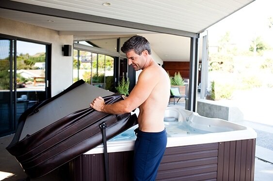 A man demonstrates how a hot tub cover lifter can make your hot tub more energy efficient and extend the life of your hot tub and your hot tub cover