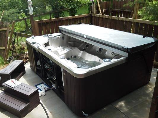 a hot tub on a deck with the maintenance access panel exposed for easy reach