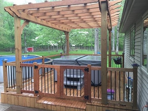 a beautiful patio deck with a hot tub and child safety fence