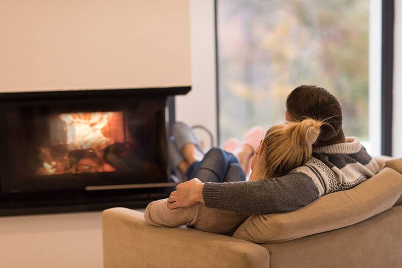 couple sitting in front of fireplace